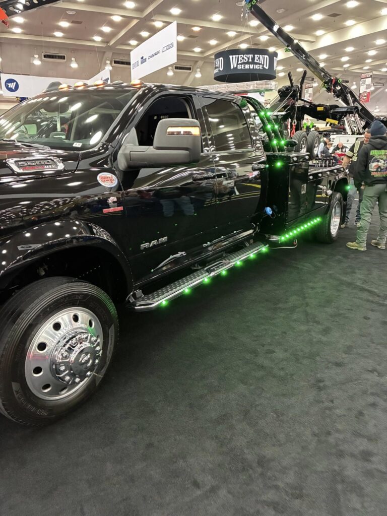 black tow truck with green accent lights at the American Towman Show in Baltimore.