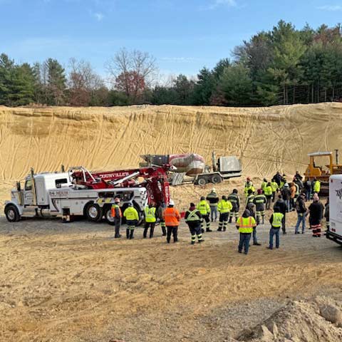 Towing operators observing heavy-duty recovery demonstration on dirt terrain at TRPC Advanced PFC training in Willimantic CT