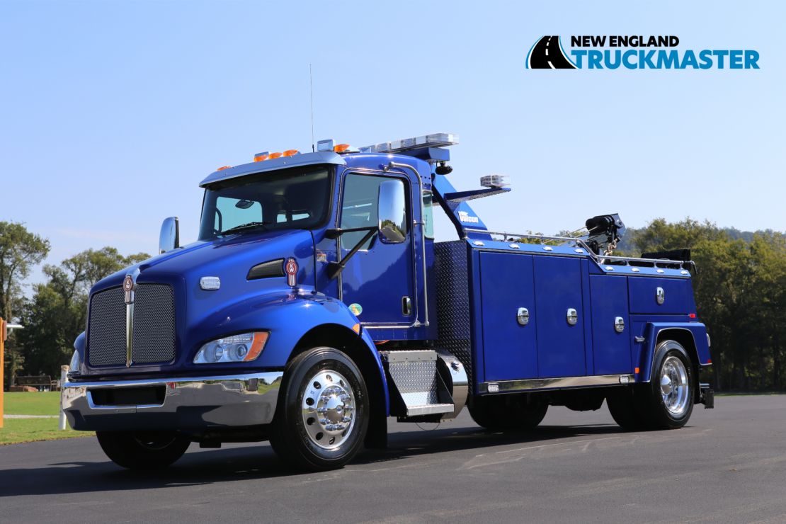 blue Kenworth tow truck sitting on asphalt